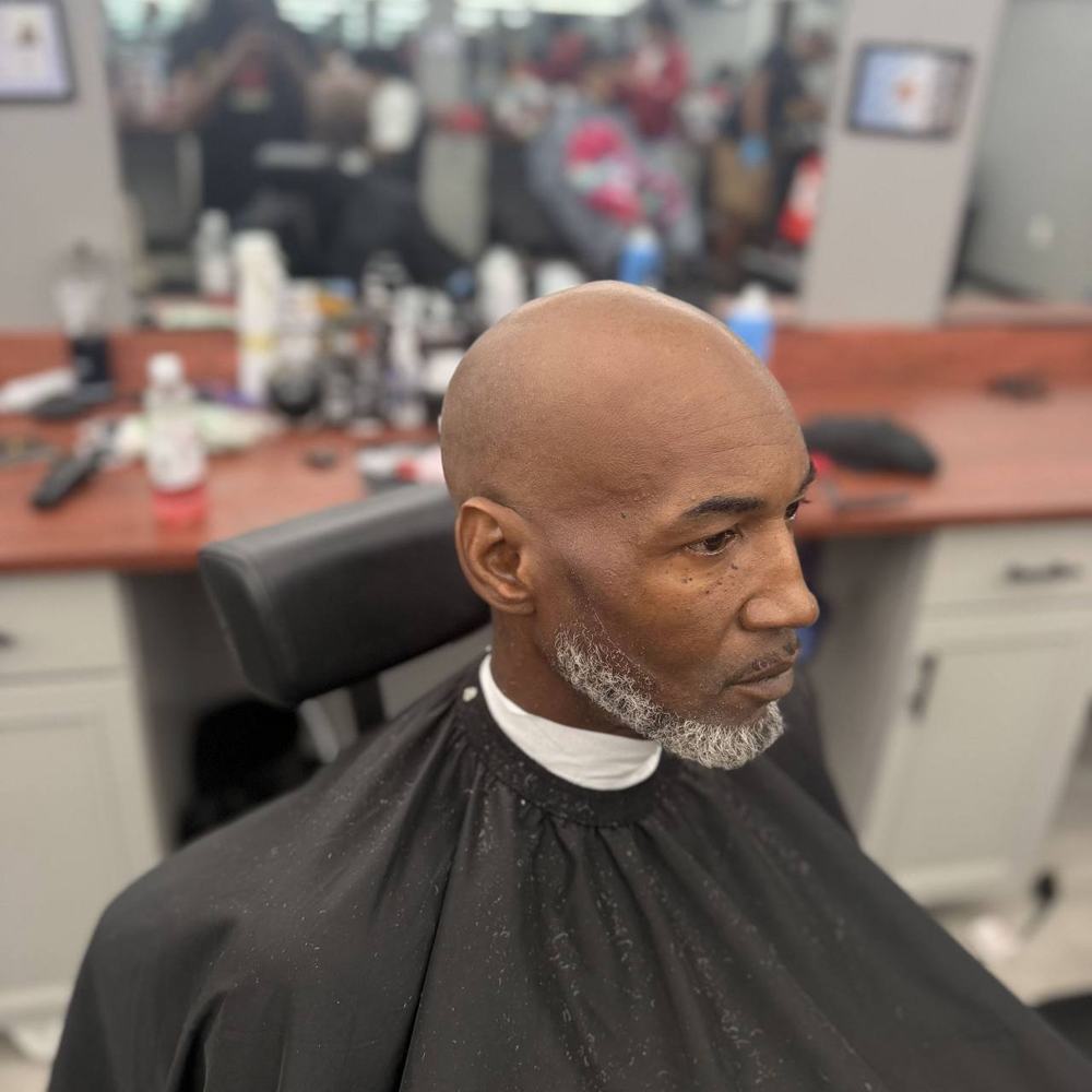 Smooth head shave with a trimmed grey beard